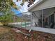 Outdoor view of screen enclosed patio with in-ground pool and lounging area, perfect for relaxation and entertaining at 6516 Hillview Rd, Spring Hill, FL 34606