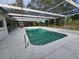 In-ground swimming pool featuring a screened enclosure, patio area, and convenient access stairs at 6516 Hillview Rd, Spring Hill, FL 34606