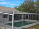 Enclosed outdoor pool area with turquoise water and patio seating, accessible from the home's exterior at 6516 Hillview Rd, Spring Hill, FL 34606