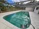 Relaxing in-ground pool with screen enclosure and patio area for outdoor enjoyment and privacy at 6516 Hillview Rd, Spring Hill, FL 34606