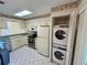 Well-lit kitchen featuring modern appliances and a convenient, stacked washer-dryer unit at 6527 Spring Flower Dr # 24, New Port Richey, FL 34653
