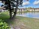 Beautiful lake view showcases the community buildings from a grassy shoreline on a clear day at 6527 Spring Flower Dr # 24, New Port Richey, FL 34653