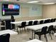 Bright meeting room with tables, chairs, and a large screen monitor, perfect for community events at 6527 Spring Flower Dr # 24, New Port Richey, FL 34653