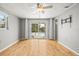 Bedroom featuring hardwood floors, ceiling fan, and glass sliding doors to the pool at 6552 River Rd, New Port Richey, FL 34652