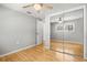 Bedroom with mirrored closet doors, ceiling fan, and hardwood floors at 6552 River Rd, New Port Richey, FL 34652