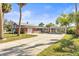 Spacious property featuring a red brick exterior, long driveway, and carport, surrounded by mature trees at 6552 River Rd, New Port Richey, FL 34652