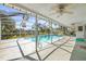 Relaxing screened-in pool area with ceiling fans and beautiful views of the lush backyard at 6552 River Rd, New Port Richey, FL 34652