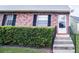 Charming brick home featuring a well-maintained front entrance with black shutters and manicured landscaping at 6710 Hickorywood Ln # 1B, New Port Richey, FL 34653