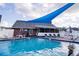 Community pool with shade, lounge chairs, and meticulous brick pavers offer a relaxing and entertaining space at 6710 Hickorywood Ln # 1B, New Port Richey, FL 34653