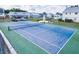 An aerial view of the community tennis court and well maintained surrounding homes at 6710 Hickorywood Ln # 1B, New Port Richey, FL 34653