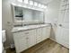 Bright bathroom with double sink vanity, granite countertops, and wood-look floors at 7026 Whitethorn Ct, Port Richey, FL 34668