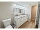 Bright bathroom with double sink vanity, granite countertops, and wood-look floors at 7026 Whitethorn Ct, Port Richey, FL 34668