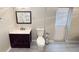 Bathroom features wood cabinet sink, toilet, and outside access at 7026 Whitethorn Ct, Port Richey, FL 34668