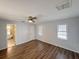 Bright and airy bedroom with wood floors, ceiling fan, and a view into the bathroom at 7026 Whitethorn Ct, Port Richey, FL 34668