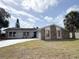 Charming single-story home featuring a stone facade, well-maintained lawn, and a paved driveway at 7026 Whitethorn Ct, Port Richey, FL 34668