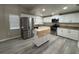 Renovated kitchen with stainless steel appliances, granite countertops, white cabinets and movable island at 7026 Whitethorn Ct, Port Richey, FL 34668
