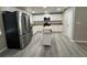 Modern kitchen with white cabinetry, stainless steel appliances, a butcher block island and gray wood-look flooring at 7026 Whitethorn Ct, Port Richey, FL 34668