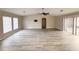 Large living room with laminate floors, ceiling fan, and sliding glass door to backyard at 7026 Whitethorn Ct, Port Richey, FL 34668