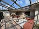 Outdoor patio with a partial enclosure, beautiful plantings, and brick pavers, perfect for relaxing at 7026 Whitethorn Ct, Port Richey, FL 34668