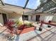 Outdoor patio with a partial enclosure, beautiful plantings, and brick pavers, perfect for relaxing at 7026 Whitethorn Ct, Port Richey, FL 34668
