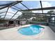 Enclosed backyard pool featuring clear blue water, a screened enclosure, and a spacious surrounding patio at 7026 Whitethorn Ct, Port Richey, FL 34668