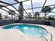 Enclosed backyard pool featuring clear blue water, a screened enclosure, and a spacious surrounding patio at 7026 Whitethorn Ct, Port Richey, FL 34668