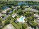 Aerial view showcasing a community pool, landscaped grounds, and well-maintained homes surrounded by mature trees at 7522 Heather Walk Dr, Weeki Wachee, FL 34613