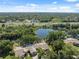 Scenic aerial view of homes near a tranquil pond and highway, surrounded by verdant trees and natural beauty at 7522 Heather Walk Dr, Weeki Wachee, FL 34613