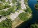Aerial view of a home with a driveway, set amidst lush trees and bordering a tranquil waterway at 7522 Heather Walk Dr, Weeki Wachee, FL 34613