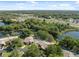 Expansive aerial view showcases a community near a tranquil pond and highway, surrounded by verdant trees at 7522 Heather Walk Dr, Weeki Wachee, FL 34613