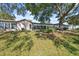 Expansive backyard featuring a lush lawn, mature trees, and a charming sunroom attached to the home at 7522 Heather Walk Dr, Weeki Wachee, FL 34613