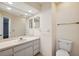 Bathroom features a large mirror, a single sink vanity with storage, and a toilet at 7522 Heather Walk Dr, Weeki Wachee, FL 34613