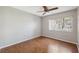 Bedroom with wood floors, ceiling fan, and a bright window providing plenty of natural light at 7522 Heather Walk Dr, Weeki Wachee, FL 34613
