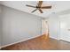 Bedroom features wood floors, a ceiling fan, and a doorway leading to other areas of the home at 7522 Heather Walk Dr, Weeki Wachee, FL 34613