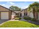 Charming front exterior featuring a well-manicured lawn and a welcoming entrance with a palm tree at 7522 Heather Walk Dr, Weeki Wachee, FL 34613