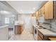 View of kitchen with tiled floors and appliances open to the living area at 7522 Heather Walk Dr, Weeki Wachee, FL 34613
