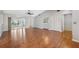 Spacious living room with hardwood floors, a ceiling fan, and sliding glass doors to a screened-in porch at 7522 Heather Walk Dr, Weeki Wachee, FL 34613