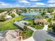 Aerial view of homes with lake, well-manicured lawns, and mature landscaping at 9032 Cypress Glen Ct, Weeki Wachee, FL 34613