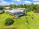 Aerial view of the back of a home featuring a large screened-in lanai/pool and picturesque landscaping at 9032 Cypress Glen Ct, Weeki Wachee, FL 34613