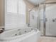 Spa-like bathroom features large tub, plantation shutters, and separate glass enclosed shower at 9032 Cypress Glen Ct, Weeki Wachee, FL 34613