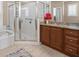 Bright bathroom featuring a glass shower, granite counters, and wood cabinets at 9032 Cypress Glen Ct, Weeki Wachee, FL 34613