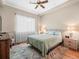Inviting bedroom with ceiling fan, hardwood floors, and large window with natural light at 9032 Cypress Glen Ct, Weeki Wachee, FL 34613