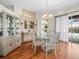 Charming dining room with a glass table, elegant chandelier, and access to the screened lanai at 9032 Cypress Glen Ct, Weeki Wachee, FL 34613