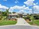 Beautiful single-story home with well-manicured lawn, landscaped garden, and a paver driveway leading to the entrance at 9032 Cypress Glen Ct, Weeki Wachee, FL 34613