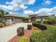 Close up showcasing the home's front exterior with well-maintained landscaping and a lengthy paver driveway at 9032 Cypress Glen Ct, Weeki Wachee, FL 34613