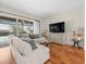 Comfortable living room featuring a large sectional sofa, and view of the screened-in pool area at 9032 Cypress Glen Ct, Weeki Wachee, FL 34613