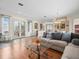 Bright living room featuring wood floors, a large sectional sofa, and elegant decor, perfect for relaxation and entertaining at 9032 Cypress Glen Ct, Weeki Wachee, FL 34613