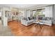 Bright living room featuring wood floors, a large sectional sofa, and elegant decor, perfect for relaxation and entertaining at 9032 Cypress Glen Ct, Weeki Wachee, FL 34613