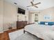 Spacious primary bedroom featuring hardwood floors, a ceiling fan, and a seating area at 9032 Cypress Glen Ct, Weeki Wachee, FL 34613