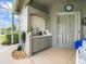 Covered outdoor kitchen with tile backsplash, sink and cabinet, plus tile floors, and view to screen porch and water at 9032 Cypress Glen Ct, Weeki Wachee, FL 34613